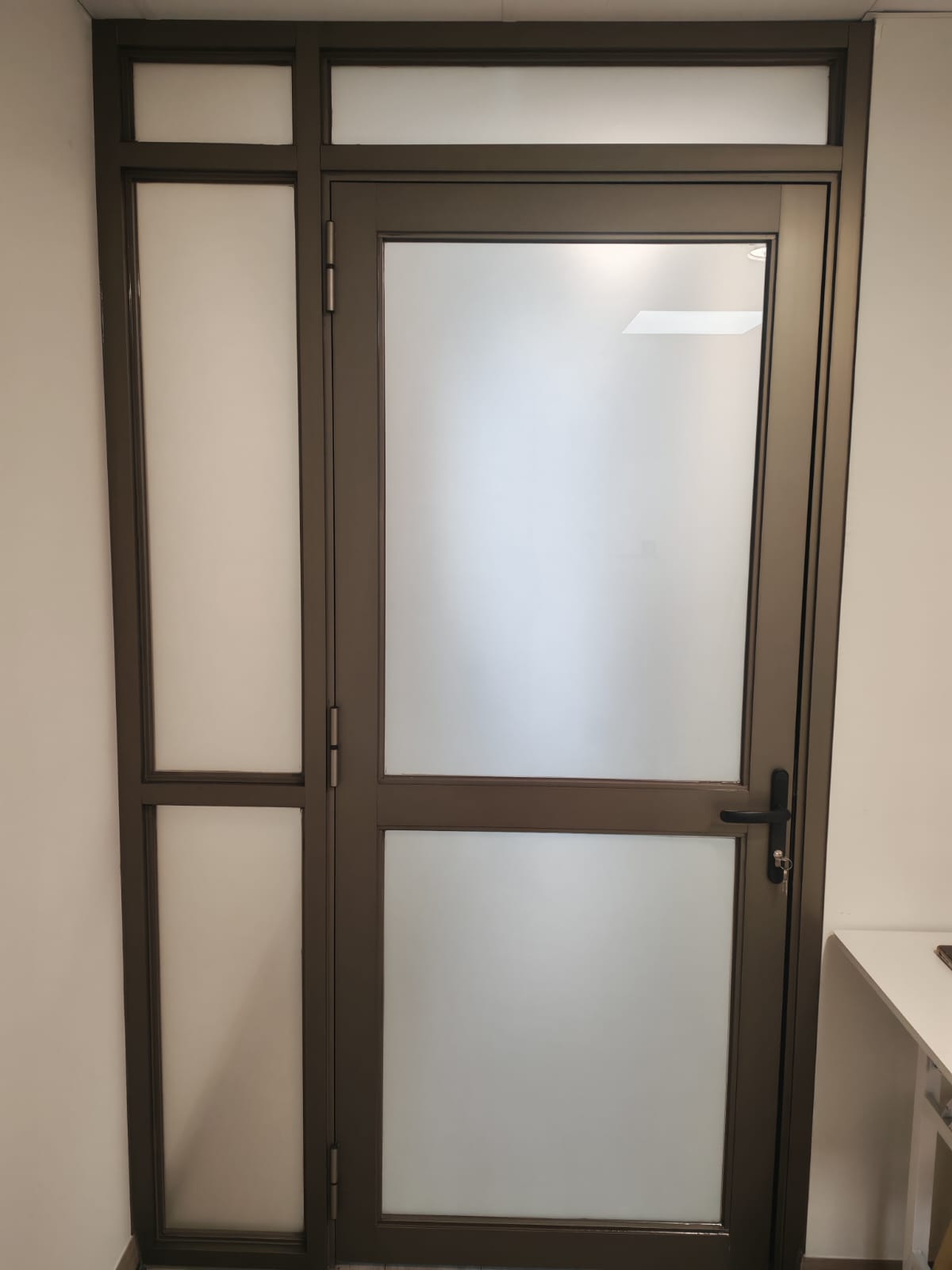 Puerta de aluminio con vidrio empavonado blanco en Antofagasta