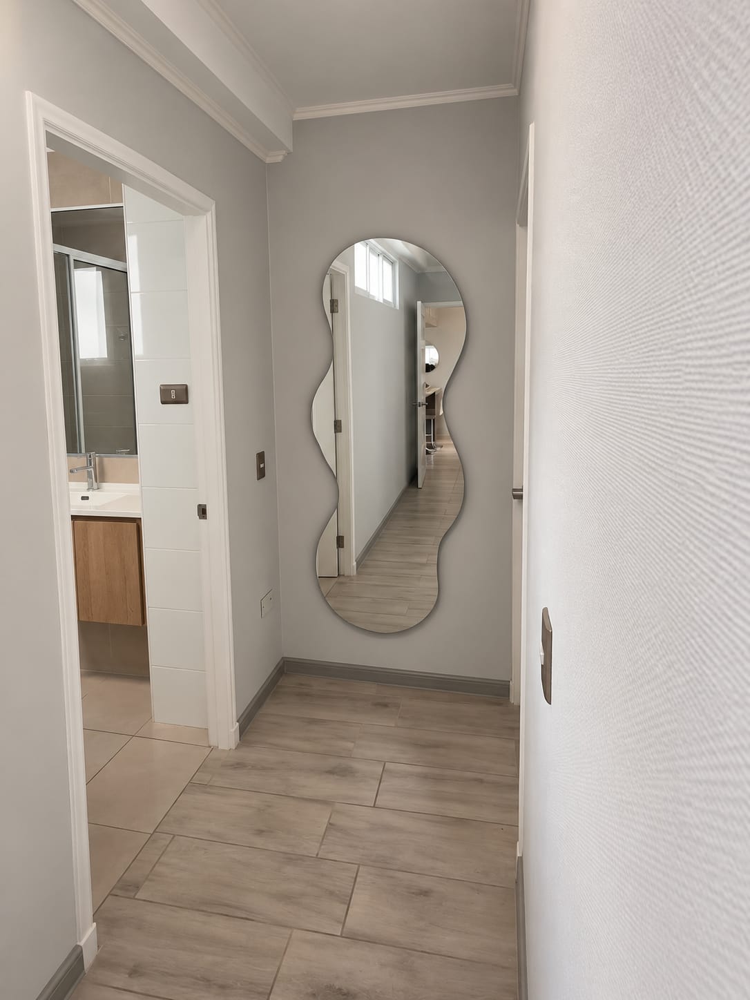 Espejo de cuerpo completo con forma irregular instalado a medida en un pasillo en Antofagasta