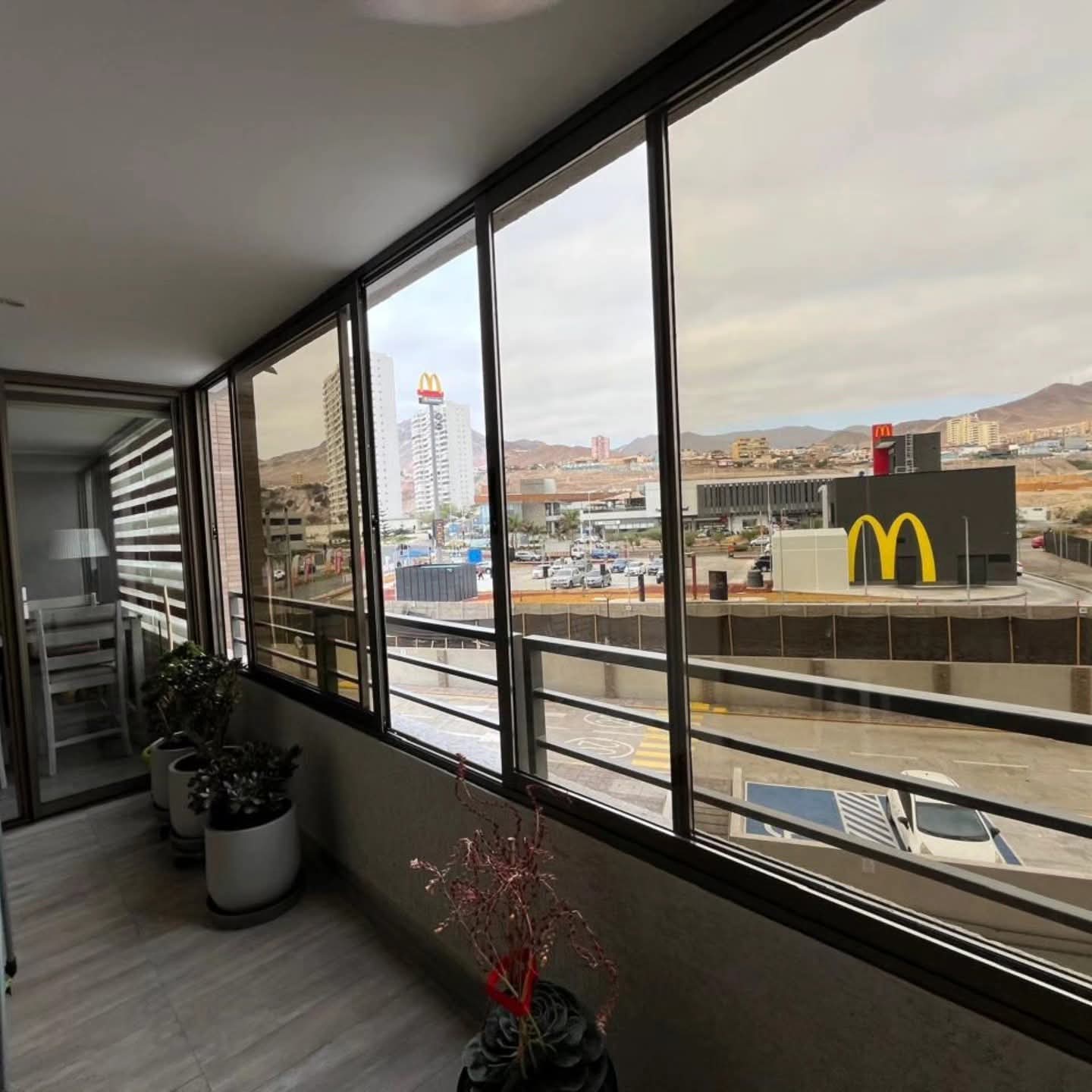 Ventanas con termopanel instaladas por JCAST en un balcón con vista a la ciudad y al mar en Antofagasta