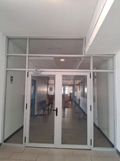 Mampara de acceso en aluminio y vidrio con puerta doble