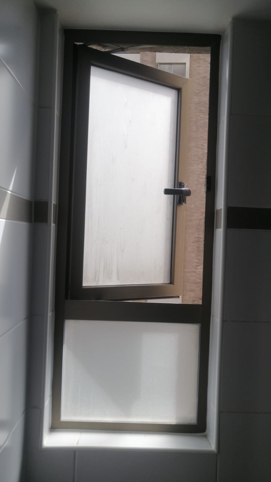 Ventana de aluminio proyectante con paño fijo instalada por JCAST en Antofagasta