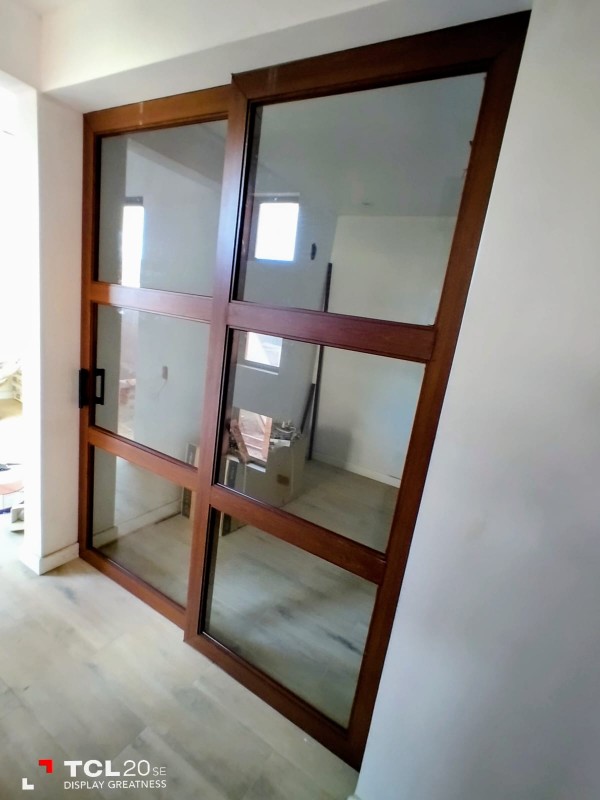 División de vidrio con estructura de aluminio en terminación madera